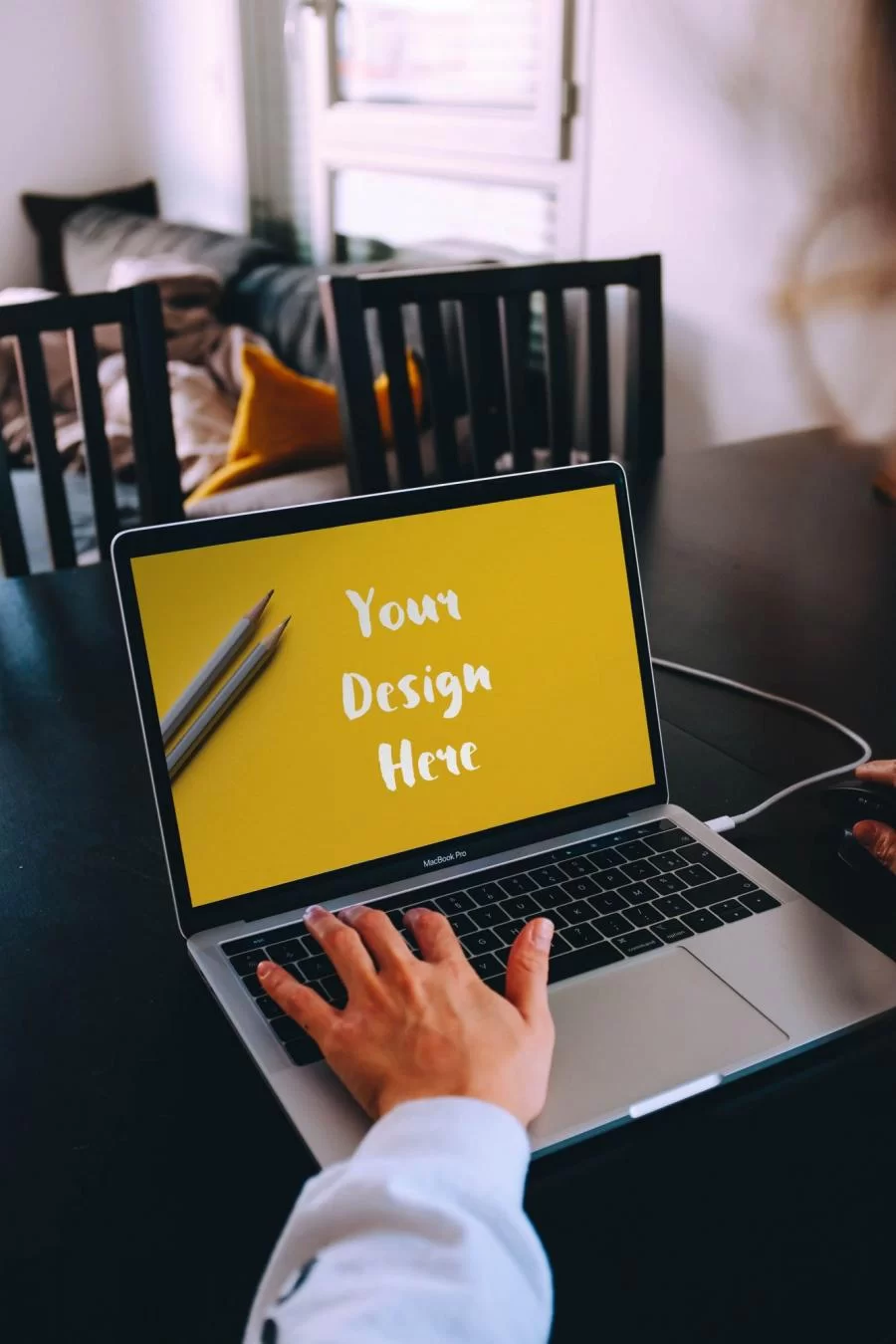 Free Woman Typing on a Macbook Pro Mockup